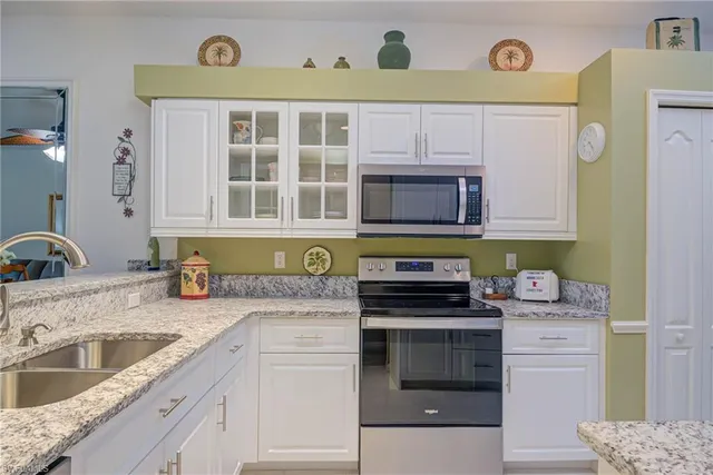 a kitchen with stainless steel appliances granite countertop a stove and cabinets