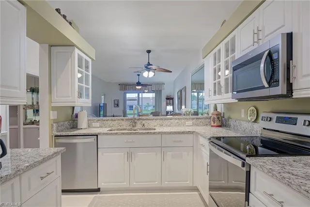 a kitchen with stainless steel appliances granite countertop a sink stove and cabinets