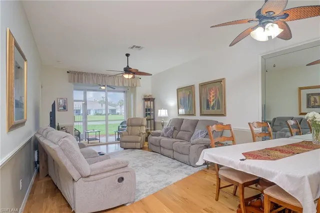 a living room with furniture a chandelier and a dining table