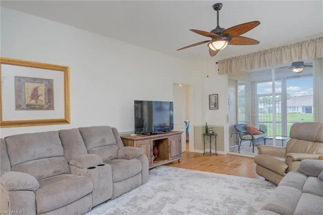 a living room with furniture a ceiling fan and a flat screen tv