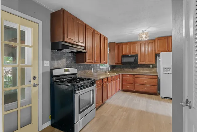 a kitchen with granite countertop wooden cabinets and stainless steel appliances