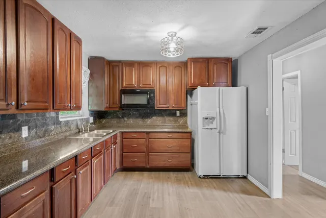 a kitchen with appliances cabinets and a sink