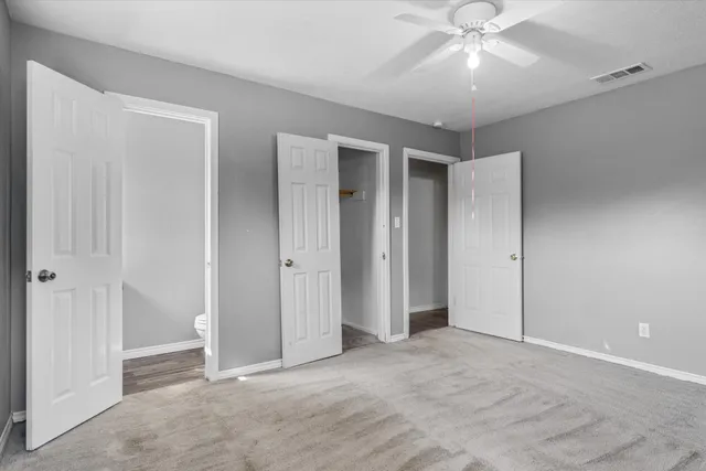 a view of an empty room with a ceiling fan