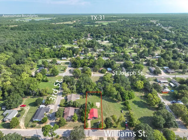 an aerial view of residential houses with outdoor space and trees