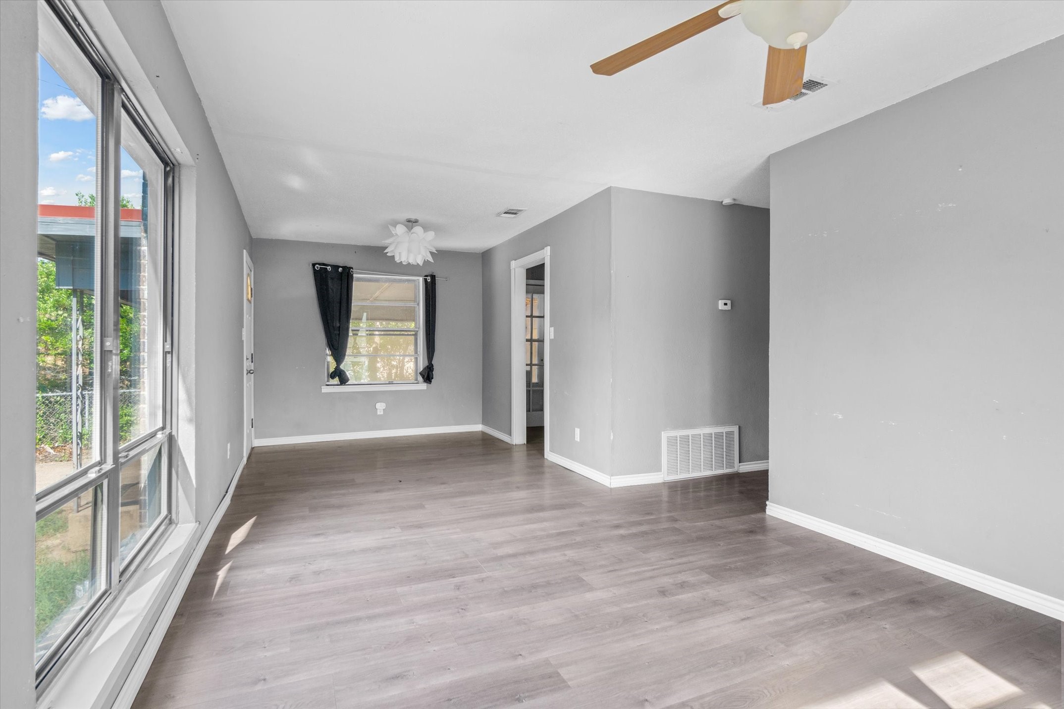 410 Williams Street Athens, TX 75751 - Photo 7 of 30 a view of an empty room with a window and wooden floor