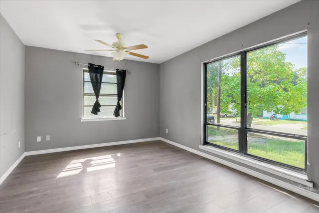an empty room with windows and balcony