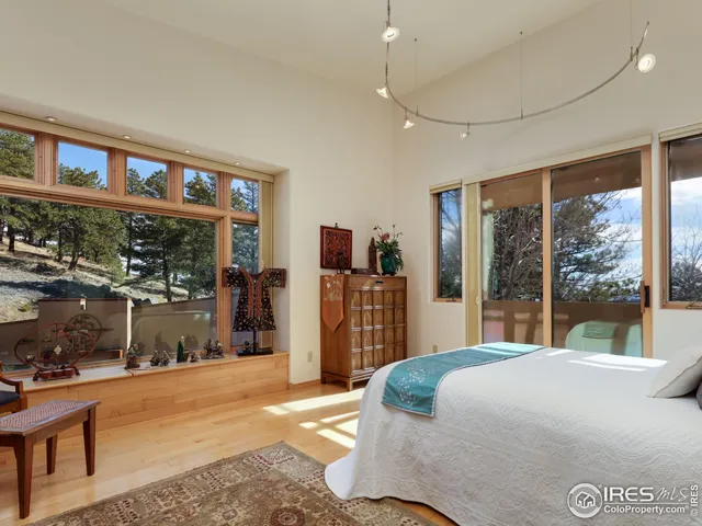 a bedroom with a large bed and a large window with outer view