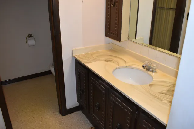 a bathroom with a granite countertop sink and a mirror