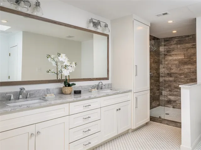 a bathroom with a granite countertop double vanity sink mirror and