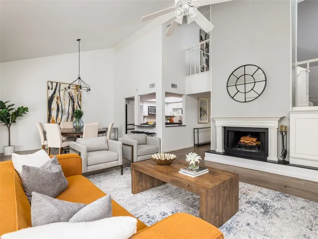 a living room with furniture a fireplace and a chandelier