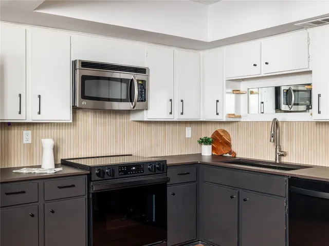 a kitchen with stainless steel appliances a stove microwave and cabinets