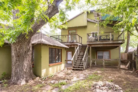 a view of a house with a small yard and wooden fence