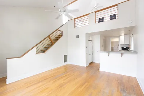 a view of empty room with wooden floor and stairs