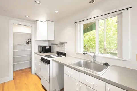 a kitchen that has a sink a stove and a microwave
