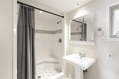 a bathroom with a sink mirror and shower
