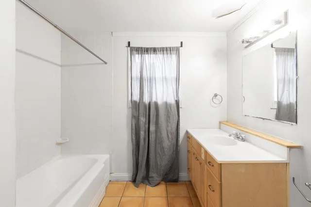 a bathroom with a tub sink and mirror