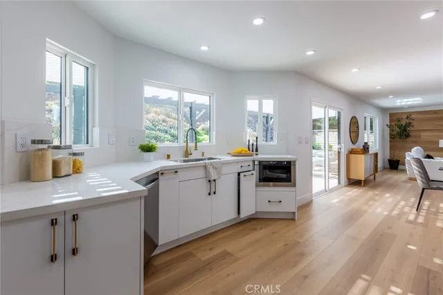 a kitchen with a sink cabinets and wooden floor