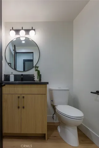 a bathroom with a toilet sink vanity and mirror