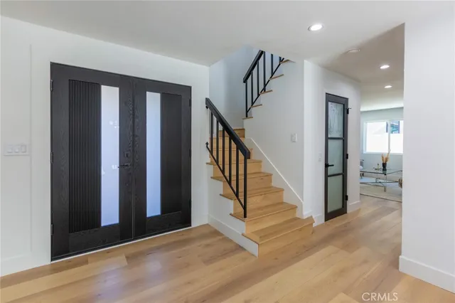 a view of a hallway with wooden floor and entryway