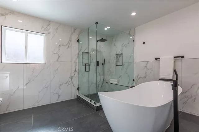 a white bath tub sitting next to a shower