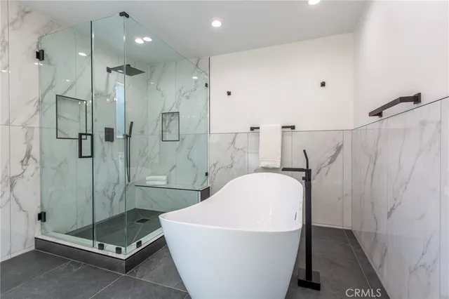 a white bath tub sitting next to a shower