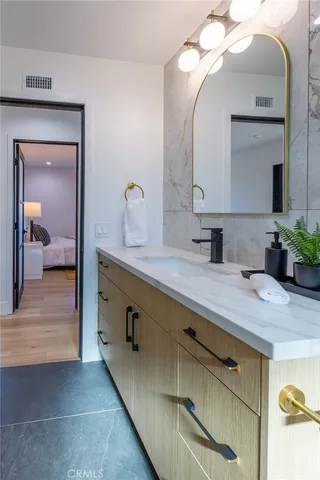 a en suite bathroom with a granite countertop sink and a mirror