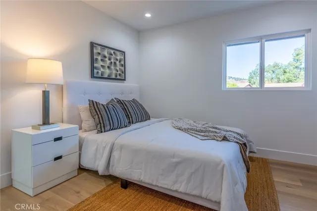 a bedroom with a bed and a lamp on dresser