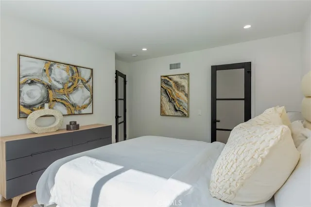 a bedroom with a bed and painting on the wall