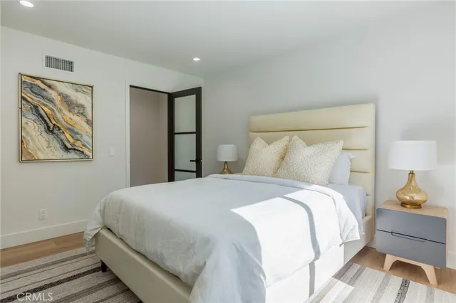 a bedroom with a bed and a lamp on dresser