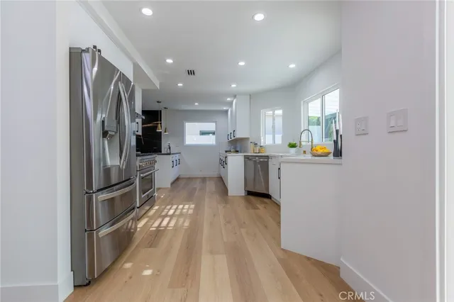 a kitchen with stainless steel appliances granite countertop a refrigerator and a sink