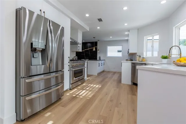 a kitchen with stainless steel appliances a refrigerator stove and sink