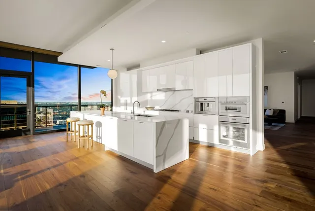 a kitchen with stainless steel appliances kitchen island granite countertop a table chairs and a refrigerator