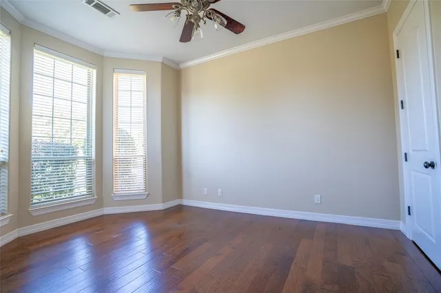 a view of an empty room with a window and wooden floor