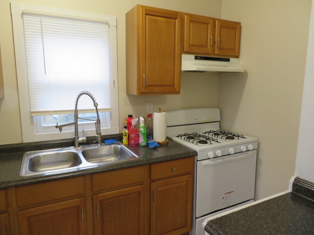 685 Cottage, Unit 1 New Bedford, MA 02745 - Photo 12 of 13 a kitchen with stainless steel appliances granite countertop a sink stove and cabinets