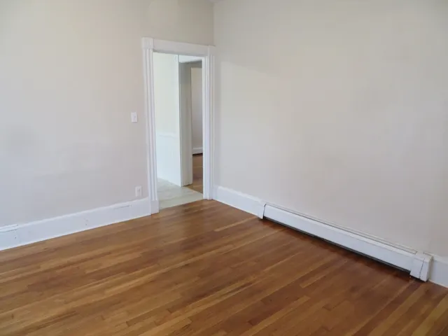 a view of an empty room with wooden floor