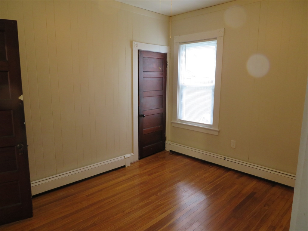 685 Cottage, Unit 1 New Bedford, MA 02745 - Photo 6 of 13 a view of an empty room with wooden floor and a window