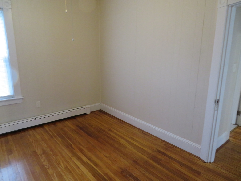 685 Cottage, Unit 1 New Bedford, MA 02745 - Photo 7 of 13 a view of an empty room with wooden floor and a window