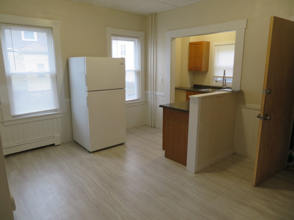 685 Cottage, Unit 1 New Bedford, MA 02745 - Photo 10 of 13 a view of a kitchen with refrigerator and wooden floor