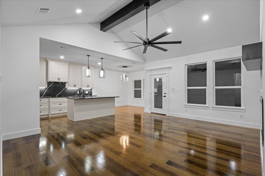 3028 West Frk Way Springtown, TX 76082 - Photo 24 of 24 Kitchen with dark countertops, white cabinetry, dark wood-style flooring, open floor plan, and a kitchen island with sink