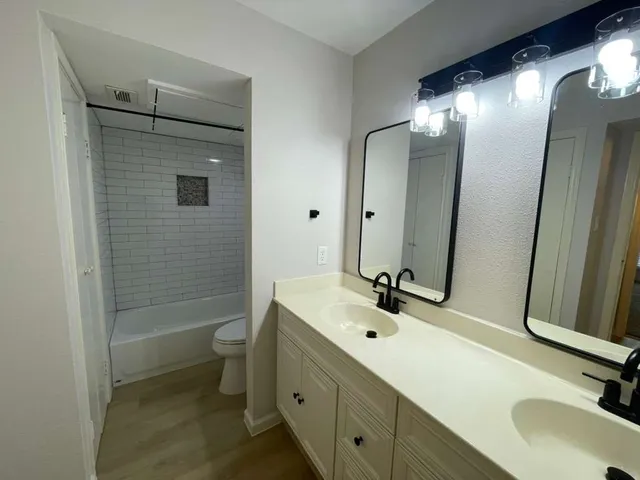 a bathroom with a sink and mirror with toilet