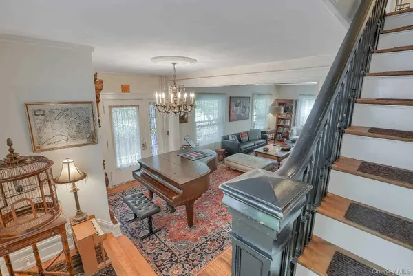 a living room with furniture a chandelier and a dining table