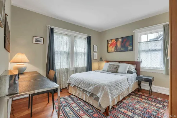 a bedroom with a bed a lamp on dresser and a window