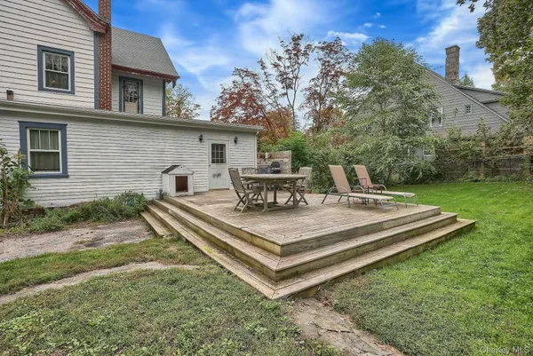 a view of a house with backyard and sitting area