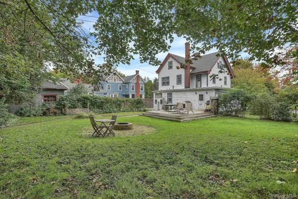 a front view of a house with a garden and trees
