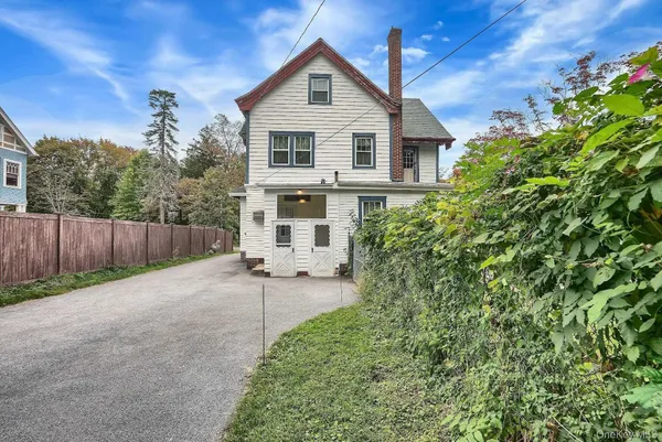 a view of a house with backyard and trees