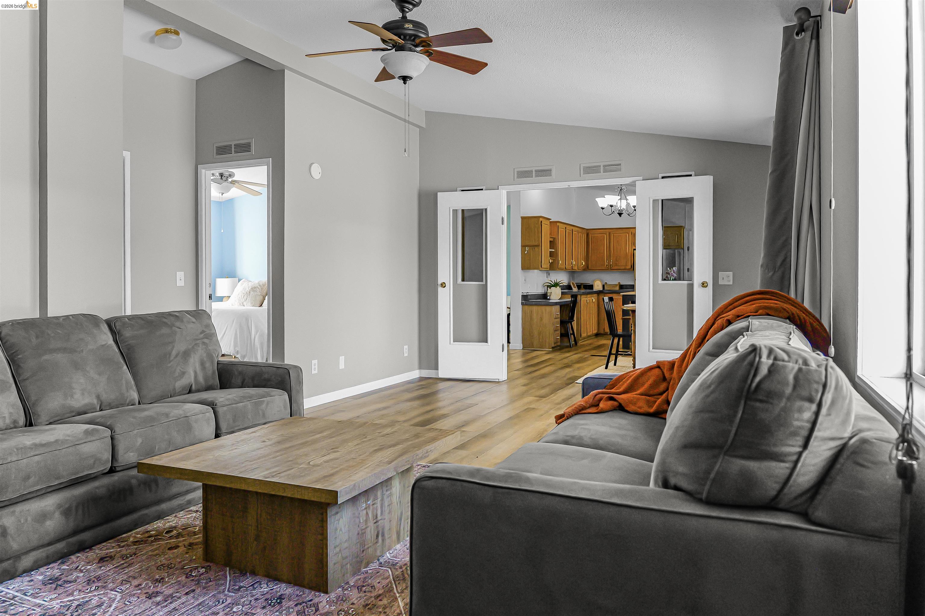4419 Little John Road Copperopolis, CA 95228 - Photo 10 of 43 Living area featuring vaulted ceilings, wood-finish flooring, a ceiling fan with integrated lighting, and white French doors