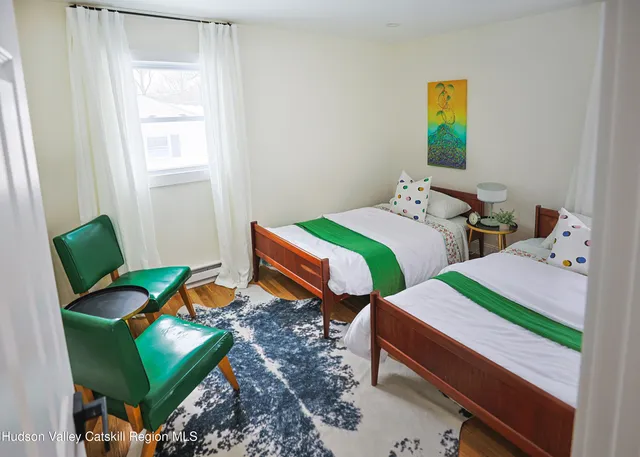 a bedroom with two beds and a chair