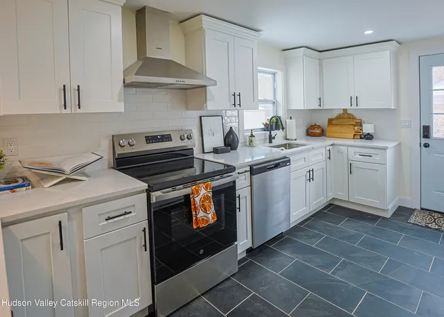 a kitchen with stainless steel appliances a stove a sink and cabinets