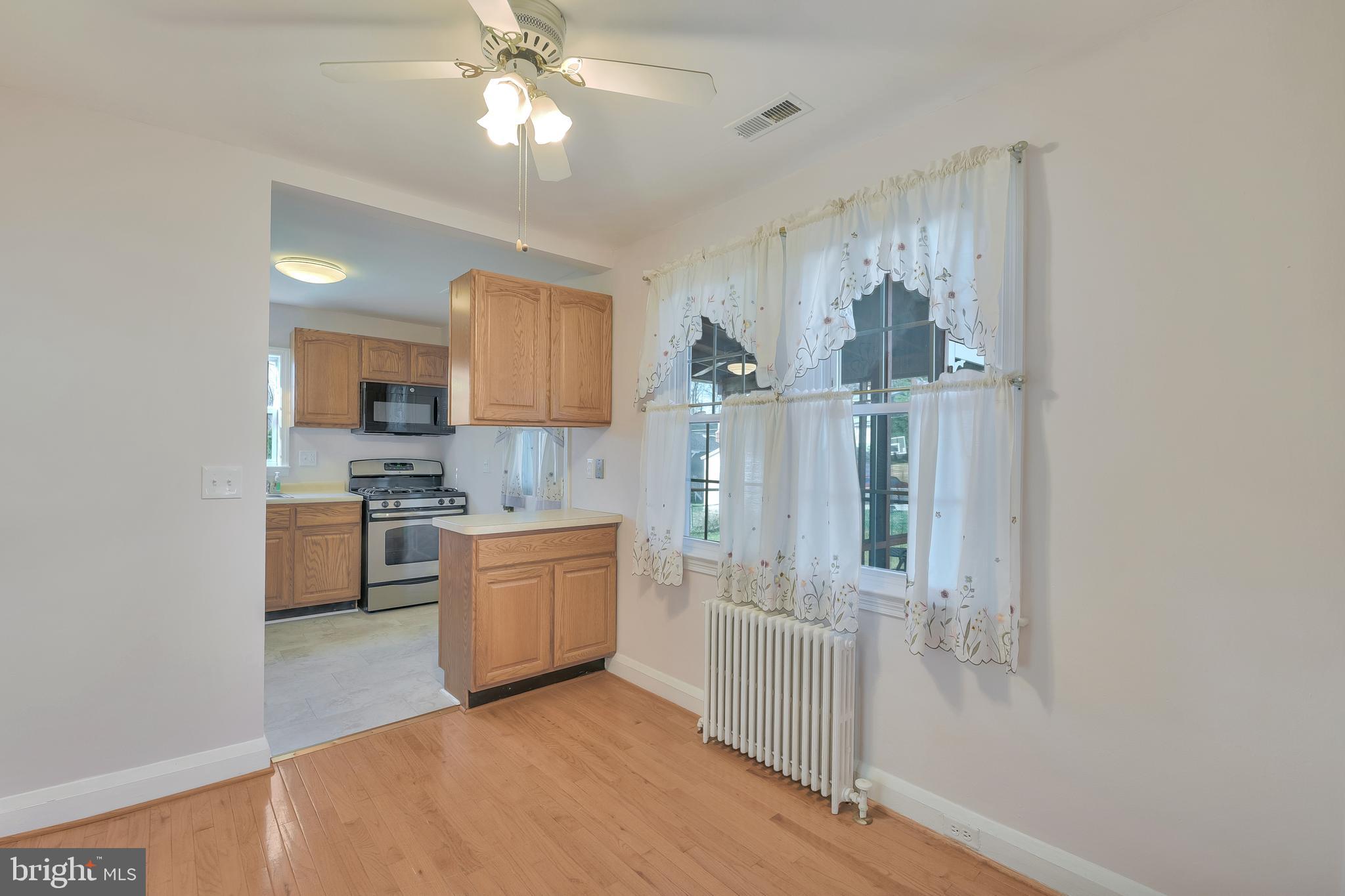 5533 Hutton Avenue Baltimore, MD 21207 - Photo 7 of 39 a kitchen with white cabinets and stainless steel appliances