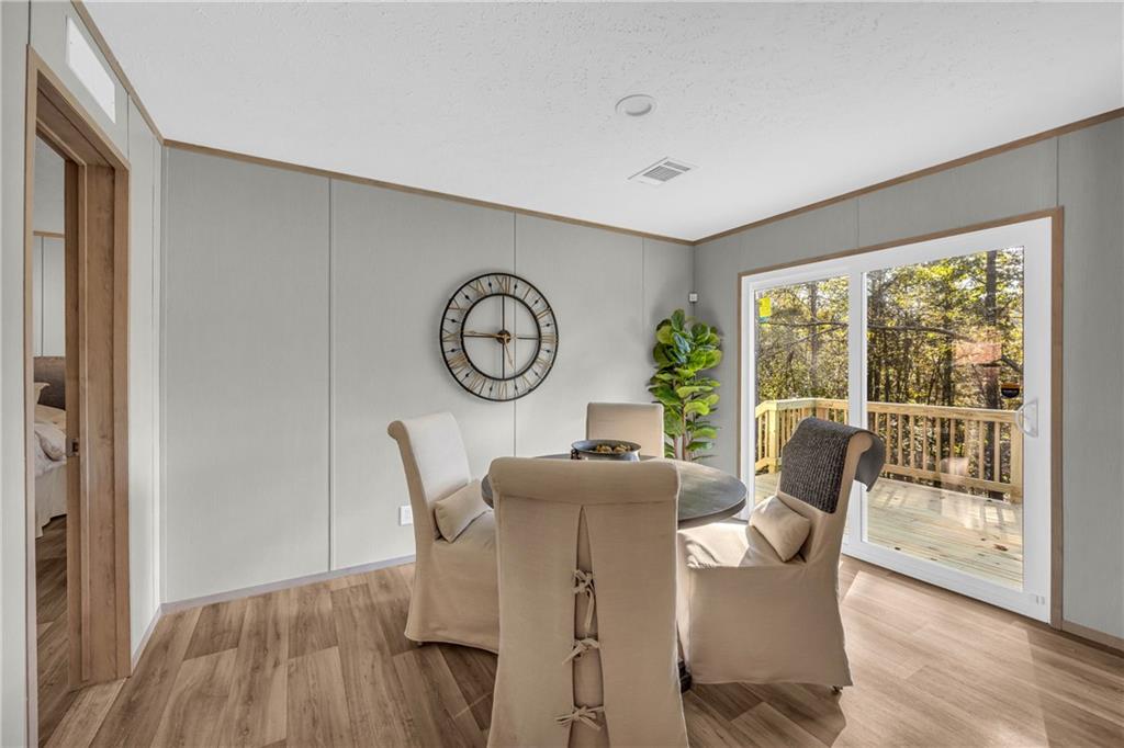 946 Essic Road Ball Ground, GA 30107 - Photo 13 of 45 a dining room with furniture a fireplace and wooden floor